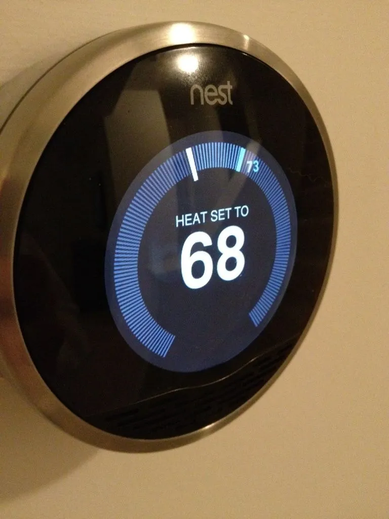 Nest thermostat on a wall showing Heat Set To 68 degrees