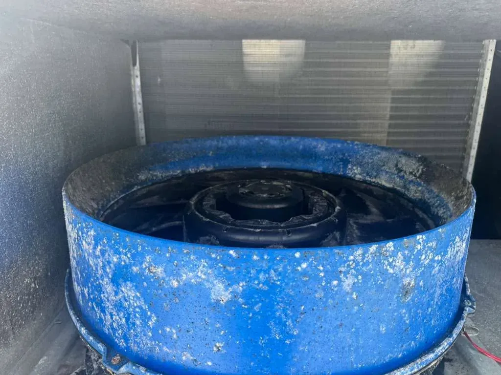 HVAC unit fan shroud coated in dirt and grime before a maintenance cleaning