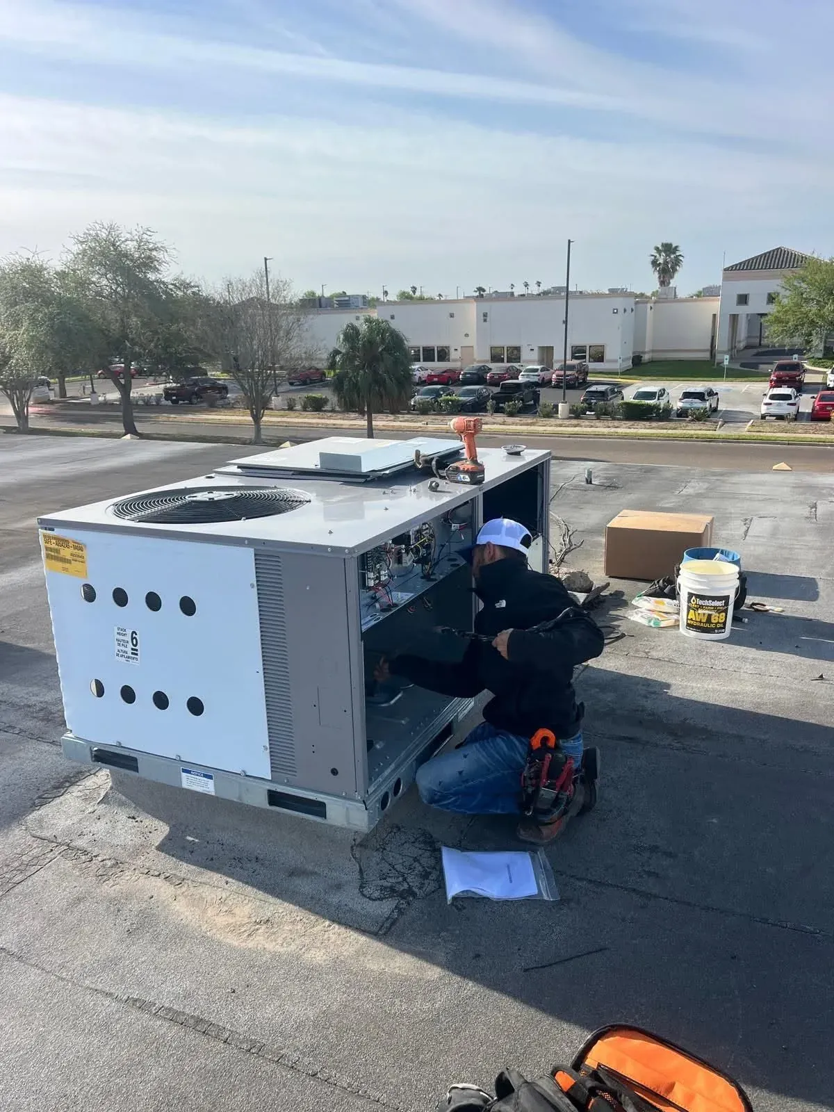 Frontier technician servicing an open commercial rooftop HVAC unit