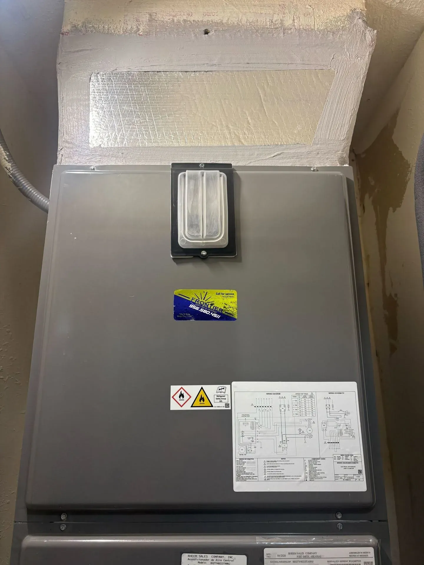 New air handler in a utility closet with a sealed supply plenum and a Frontier service sticker